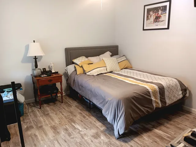 a bedroom with a bed and a lamp on table