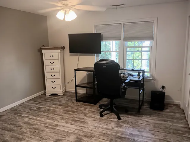 a view of a workspace with furniture and a window