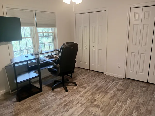 a view of a workspace with furniture and a window