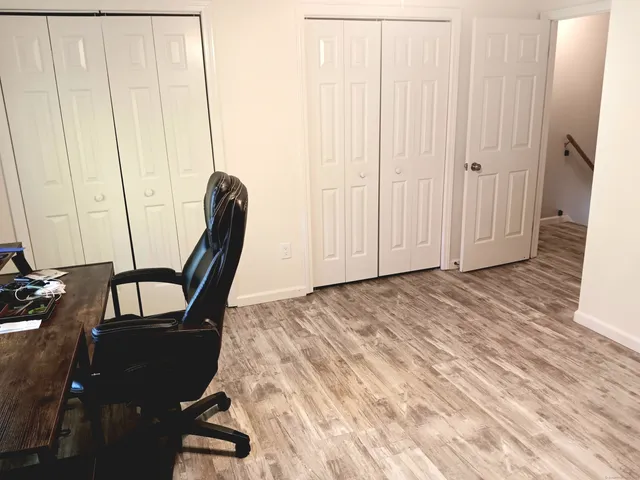 a view of a hallway with wooden floor and chair