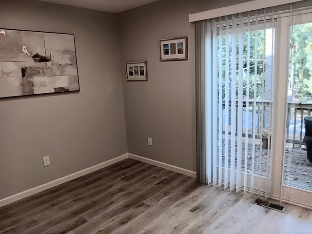 a view of a room with wooden floor and door