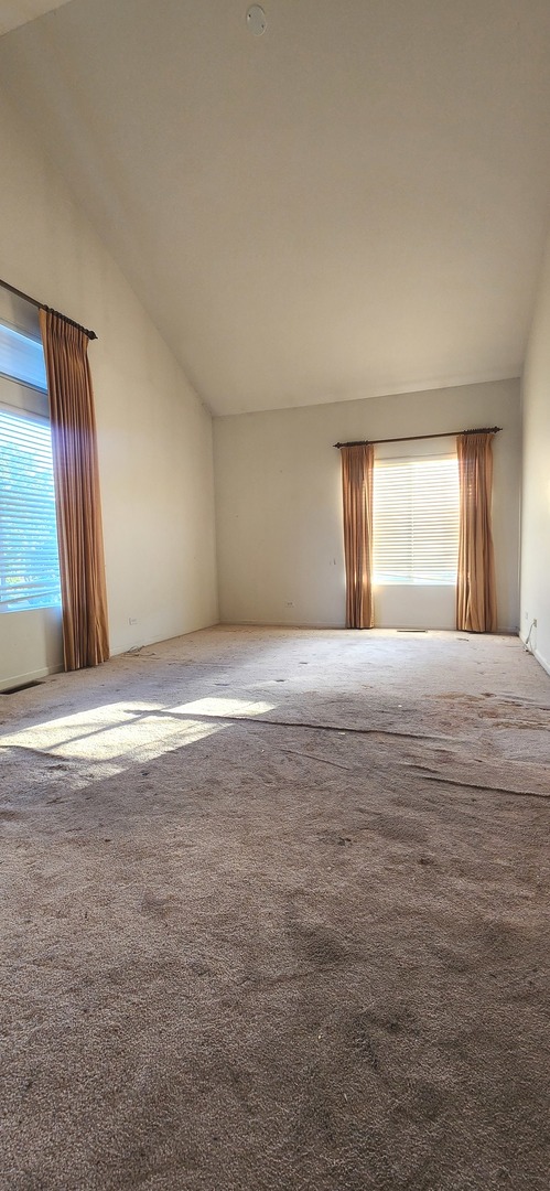 117 Enclave Circle, Unit A Bolingbrook, IL 60440 - Photo 12 of 18 a view of an empty room with window and wooden floor