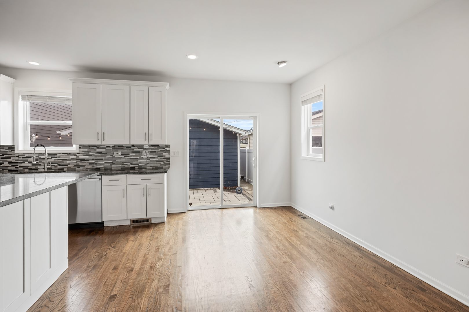 1823 35th Avenue Stone Park, IL 60165 - Photo 15 of 44 a kitchen with granite countertop a stove a sink and white cabinets with wooden floor