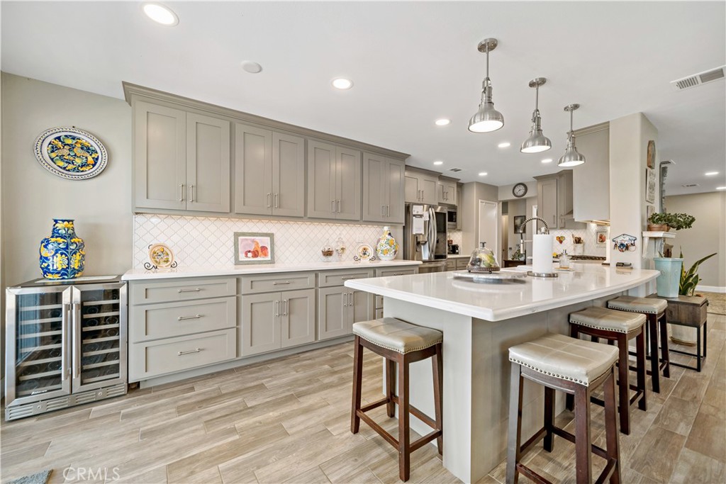 a kitchen with kitchen island granite countertop a sink a counter space appliances and cabinets