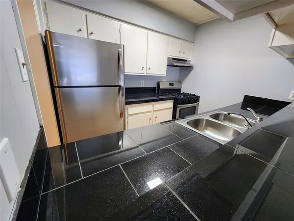 a kitchen with a refrigerator and a sink