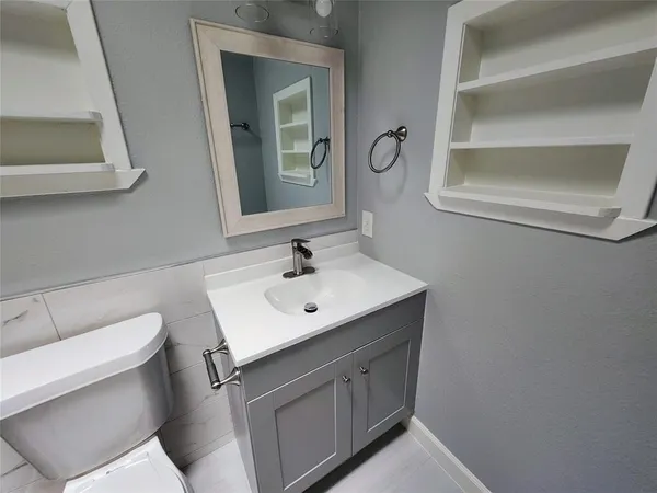 a bathroom with a sink toilet and mirror