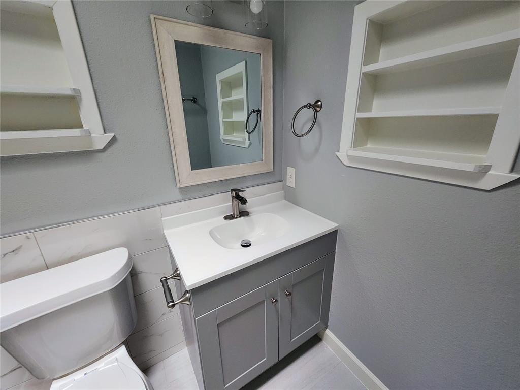 608 West 51st Street, Unit 101 Austin, TX 78751 - Photo 9 of 11 Half bath with vanity and built in shelves