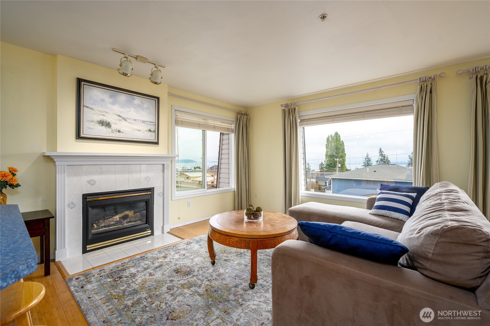 a living room with furniture a fireplace and a large window