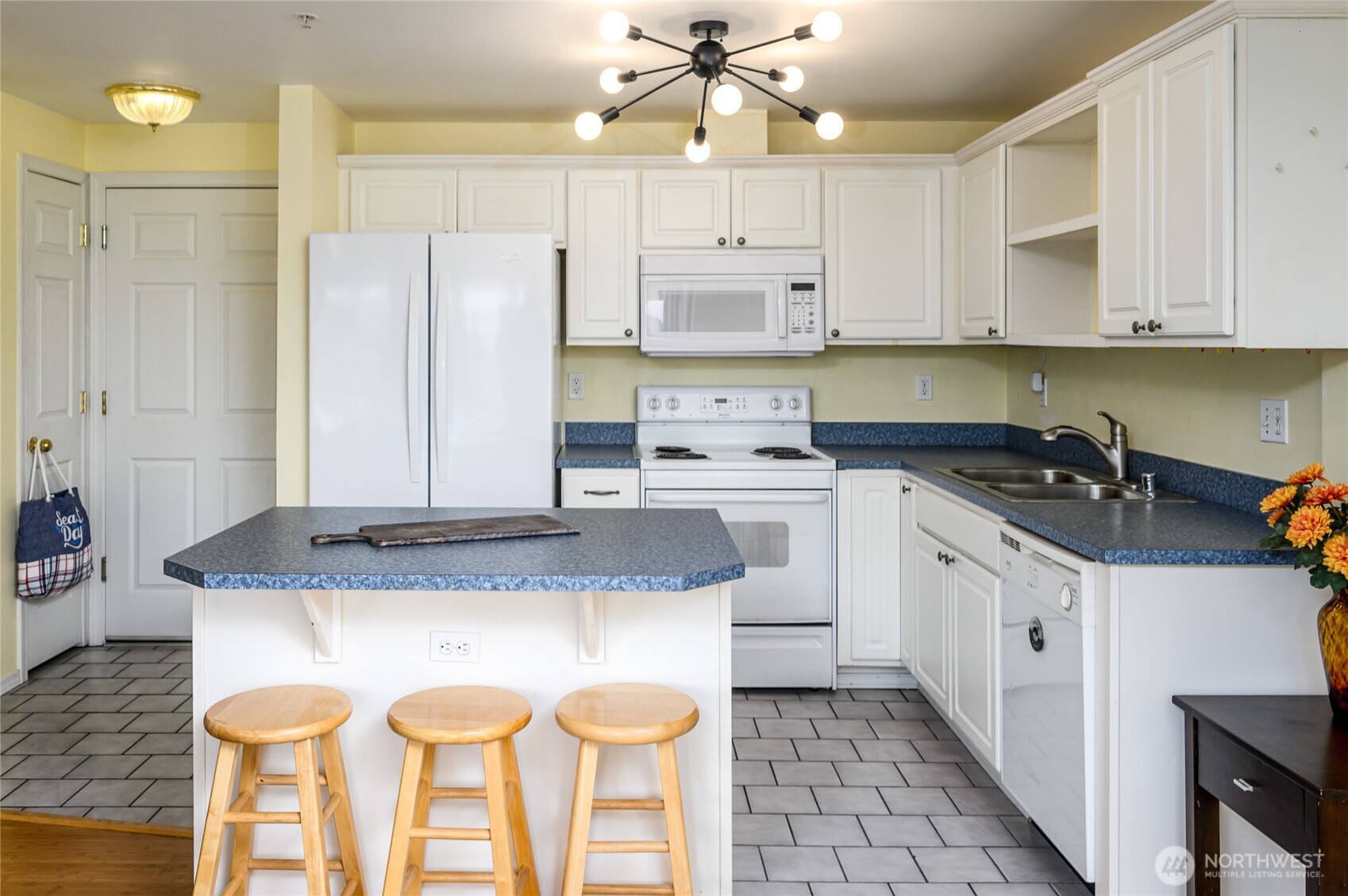 910 34th Street, Unit 202 Anacortes, WA 98221 - Photo 5 of 20 a kitchen with a sink a stove a refrigerator and white cabinets