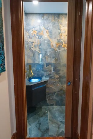 a view of kitchen with kitchen island a large window cabinets a sink and stainless steel appliances