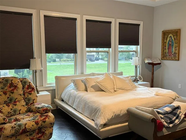 a bedroom with a bed and a large window