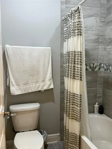 a bathroom with a toilet and a shower