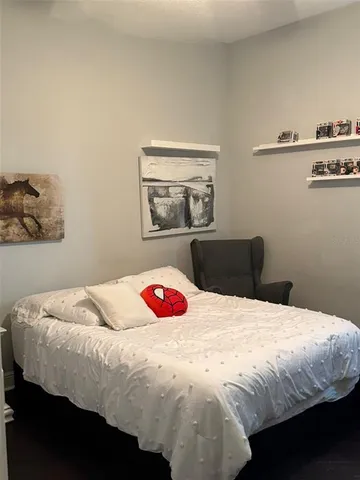 a bedroom with a bed and a painting on the wall