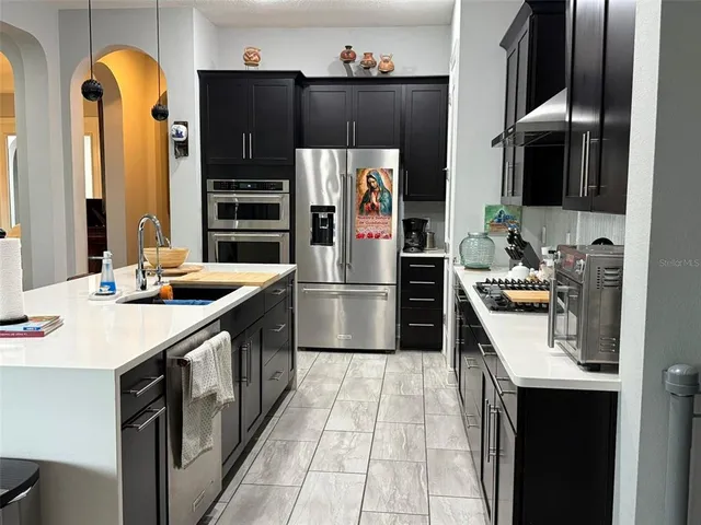 a kitchen with stainless steel appliances a refrigerator sink and microwave