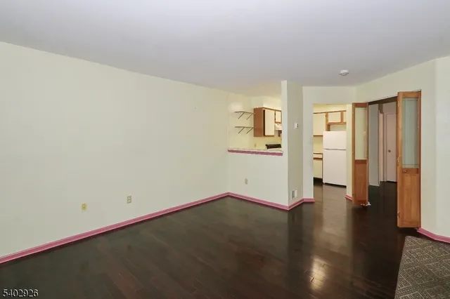a view of empty room with wooden floor and windows