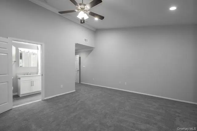 an empty room with closet and a chandelier fan