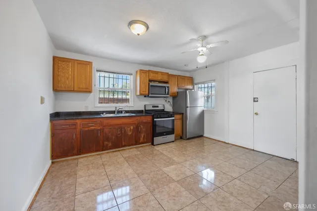 a large kitchen with granite countertop a stove a sink and a refrigerator
