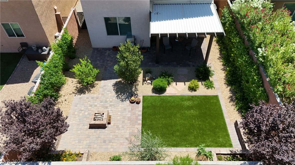 891 Earth Luster Road Las Vegas, NV 89178 - Photo 40 of 48 A private backyard oasis features lush landscaping, an inviting patio, and a cozy fire pit.