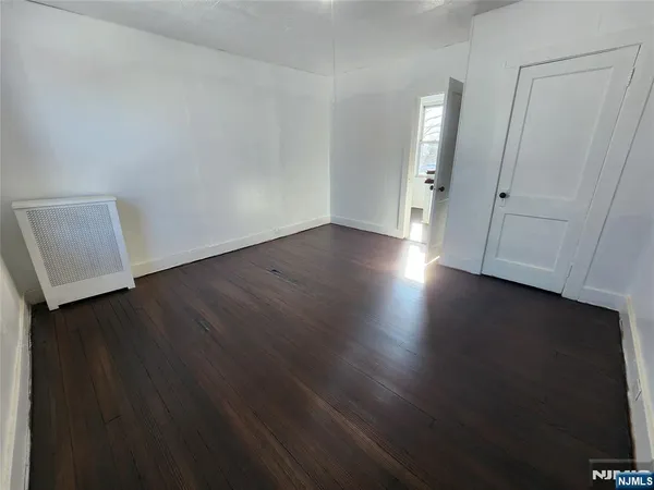 an empty room with wooden floor and closet