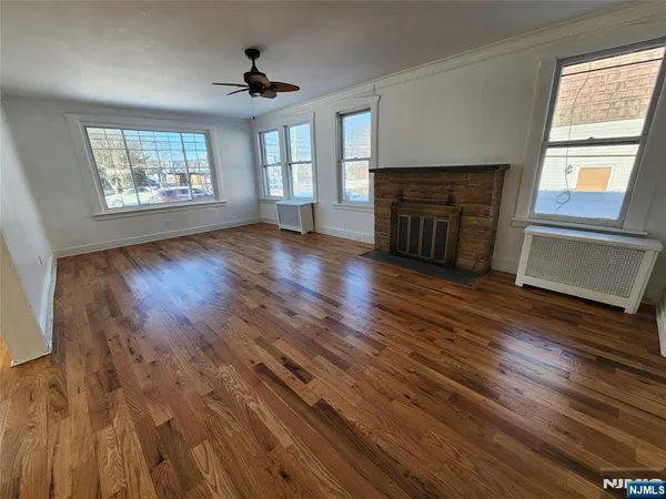 wooden floor fireplace and windows in an empty room