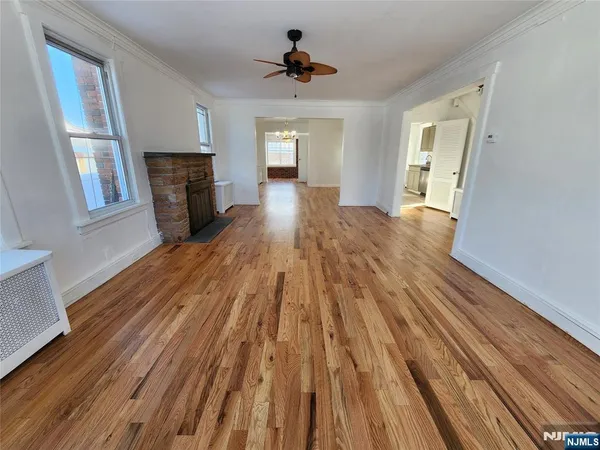 a view of empty room with wooden floor and fireplace
