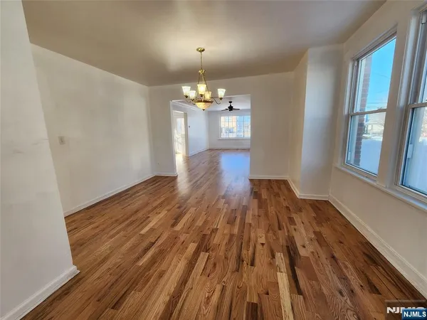 a view of a room with wooden floor and chandelier