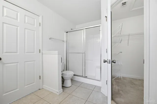 a bathroom with a granite countertop sink a toilet and shower