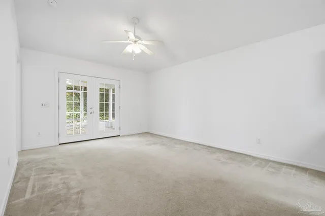 an empty room with chandelier fan