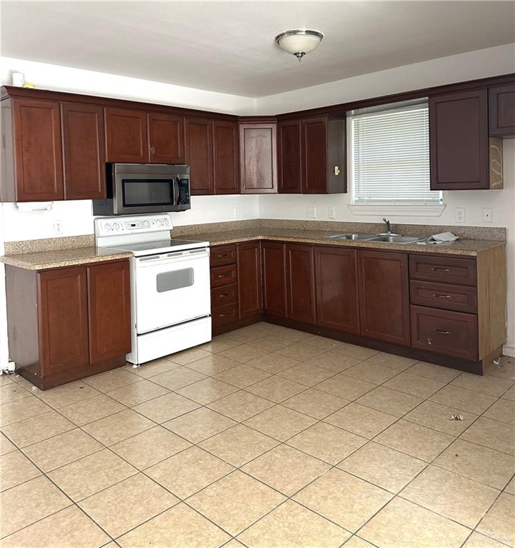 3800 South Sheraton Avenue Pharr, TX 78577 - Photo 3 of 11 a kitchen with granite countertop a stove top oven microwave and cabinets