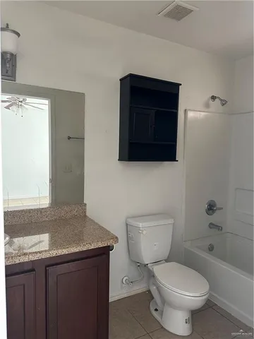 a bathroom with a granite countertop toilet a sink and a bathtub