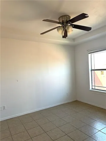an empty room with windows and ceiling fan