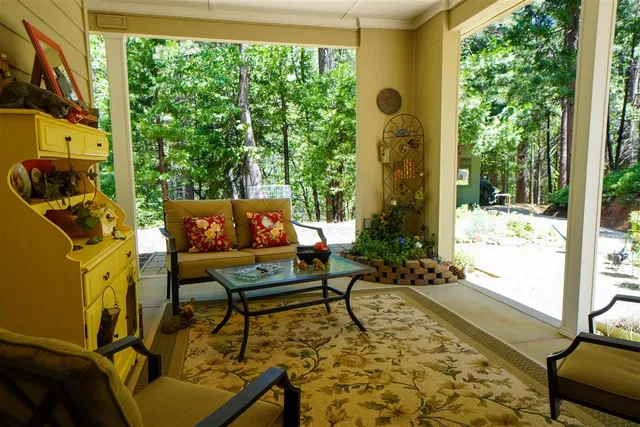 a view of a house with large trees and a small yard