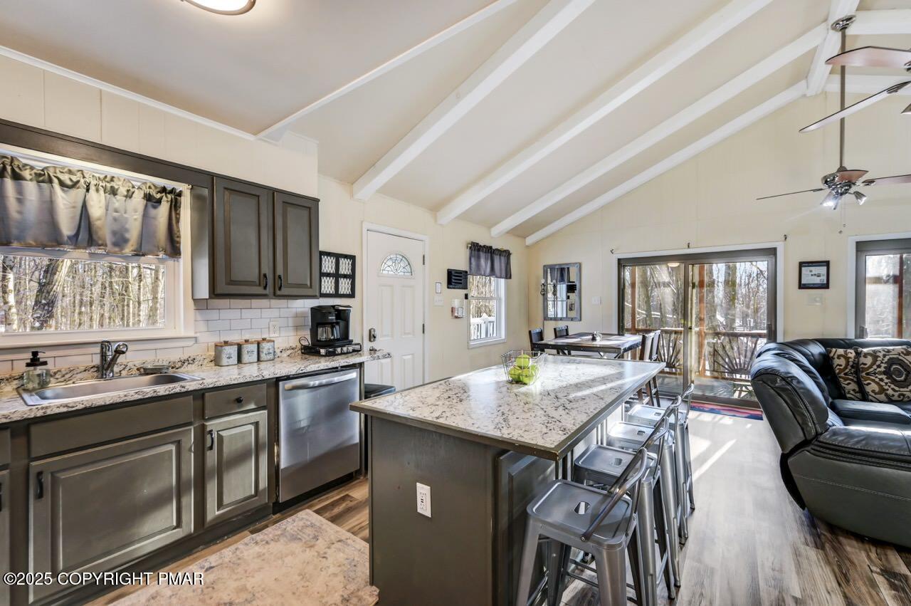 124 Fern Ridge Road Blakeslee, PA 18610 - Photo 19 of 69 a kitchen with a stove a sink dishwasher a dining table and chairs with wooden floor