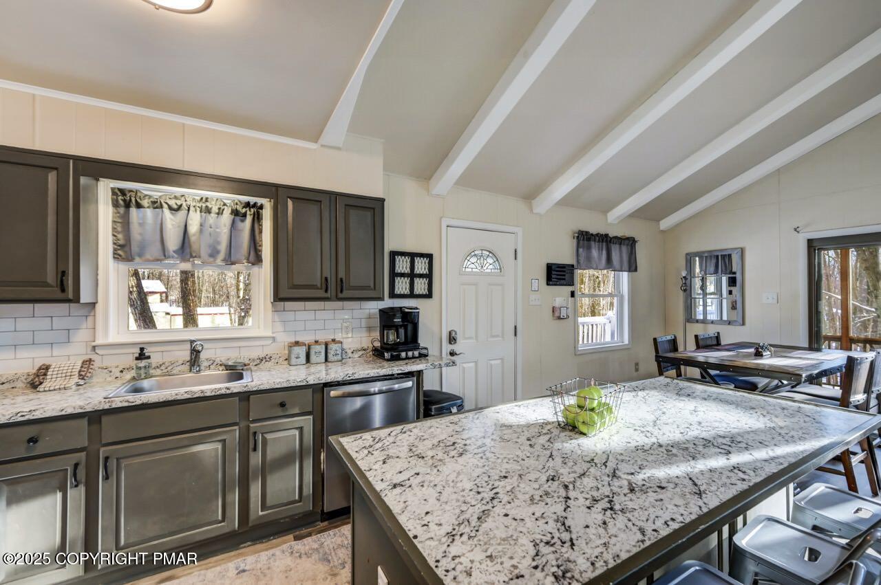 124 Fern Ridge Road Blakeslee, PA 18610 - Photo 21 of 69 a kitchen with a stove a sink dishwasher a dining table and chairs with wooden floor