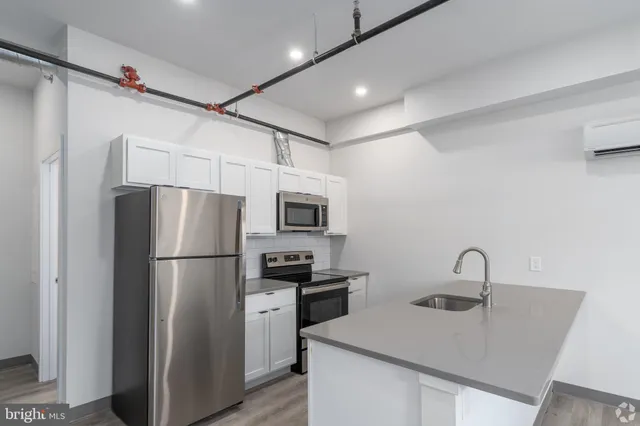 a kitchen with sink a refrigerator and a stove top oven