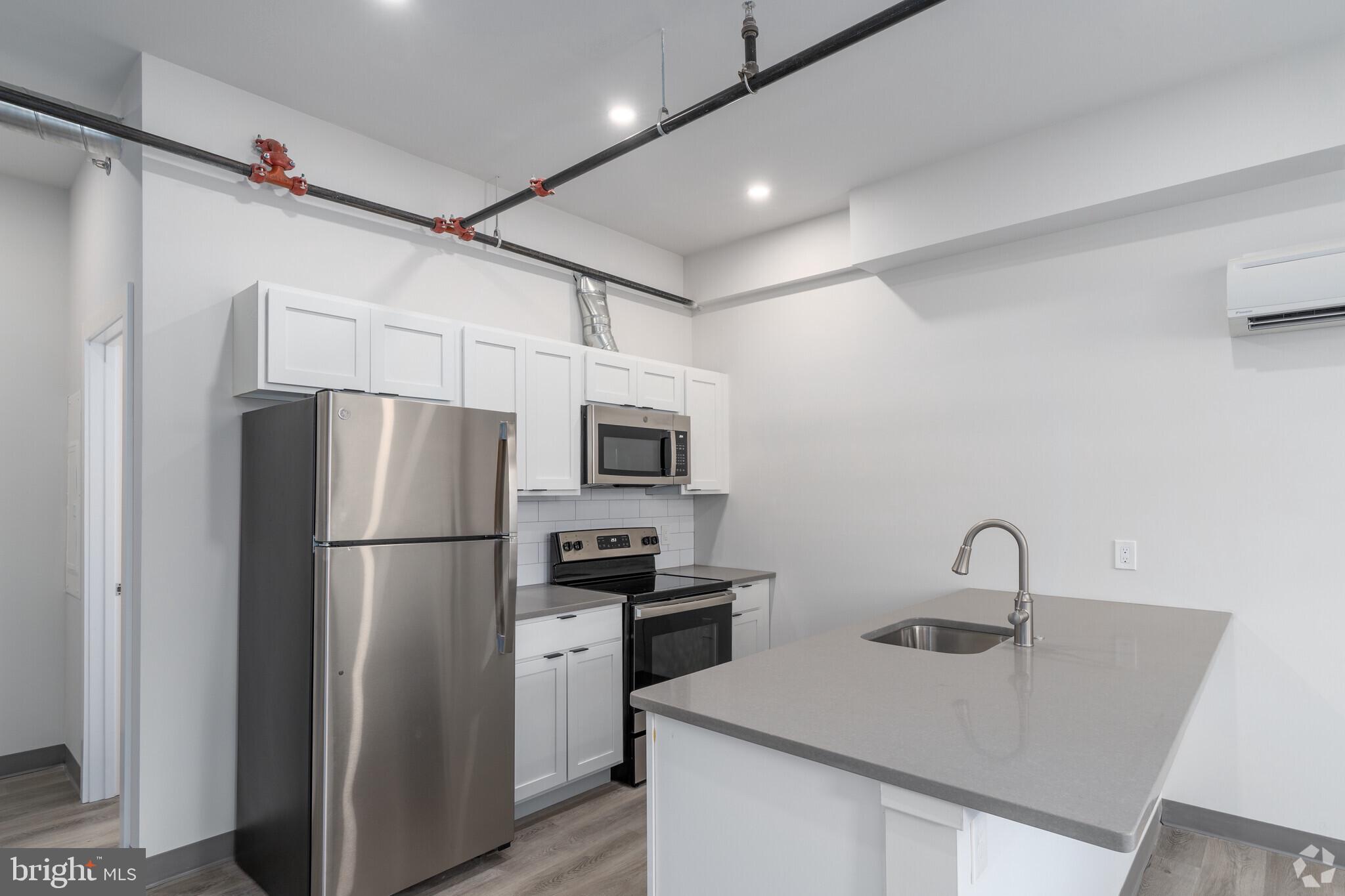 224 Hall Street, Unit 7 Phoenixville, PA 19460 - Photo 2 of 14 a kitchen with sink a refrigerator and a stove top oven