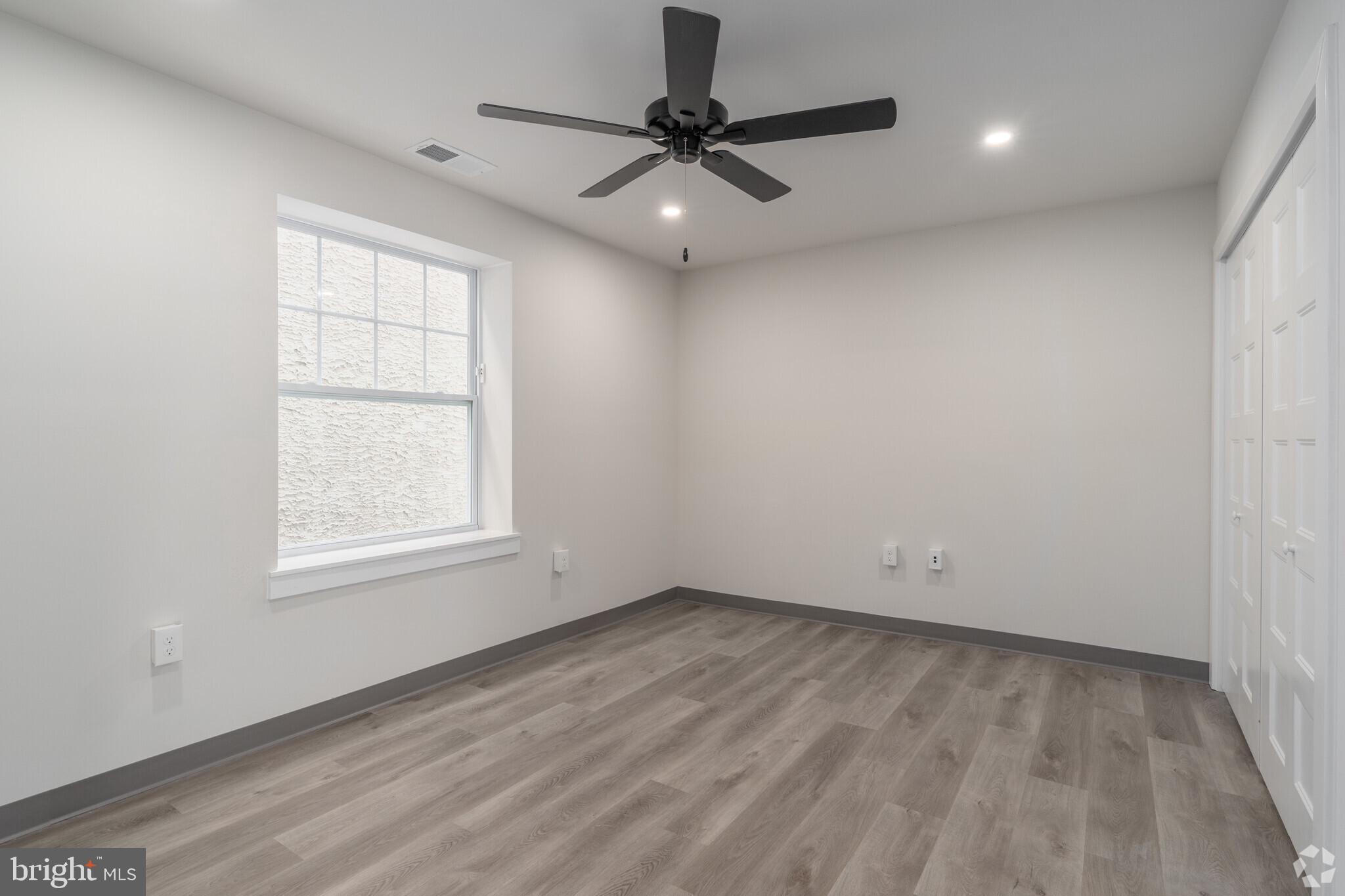 224 Hall Street, Unit 7 Phoenixville, PA 19460 - Photo 7 of 14 an empty room with a window and a ceiling fan