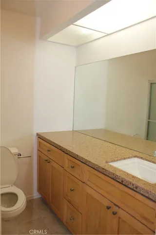 a bathroom with a granite countertop sink and toilet