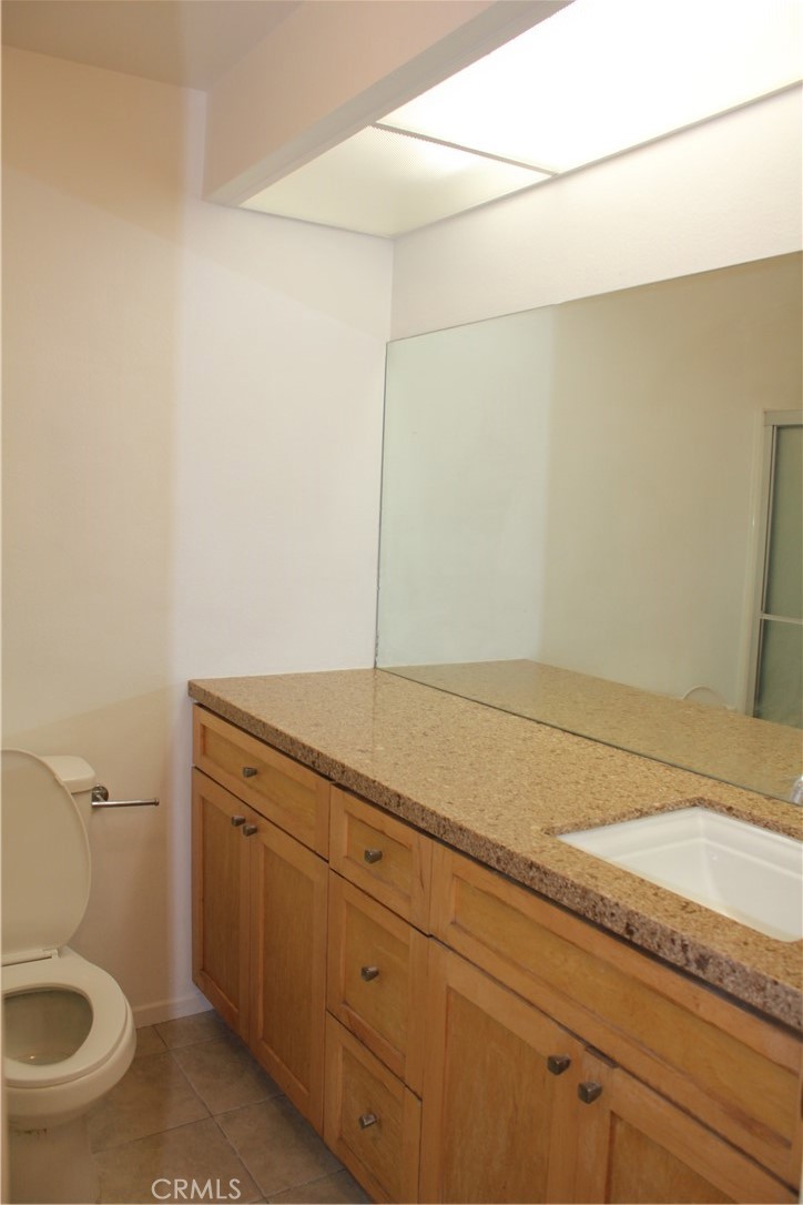 7304 Corbin Avenue, Unit F Reseda, CA 91335 - Photo 11 of 12 a bathroom with a granite countertop sink and toilet