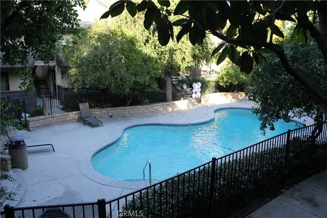 a view of a swimming pool with a patio and plants