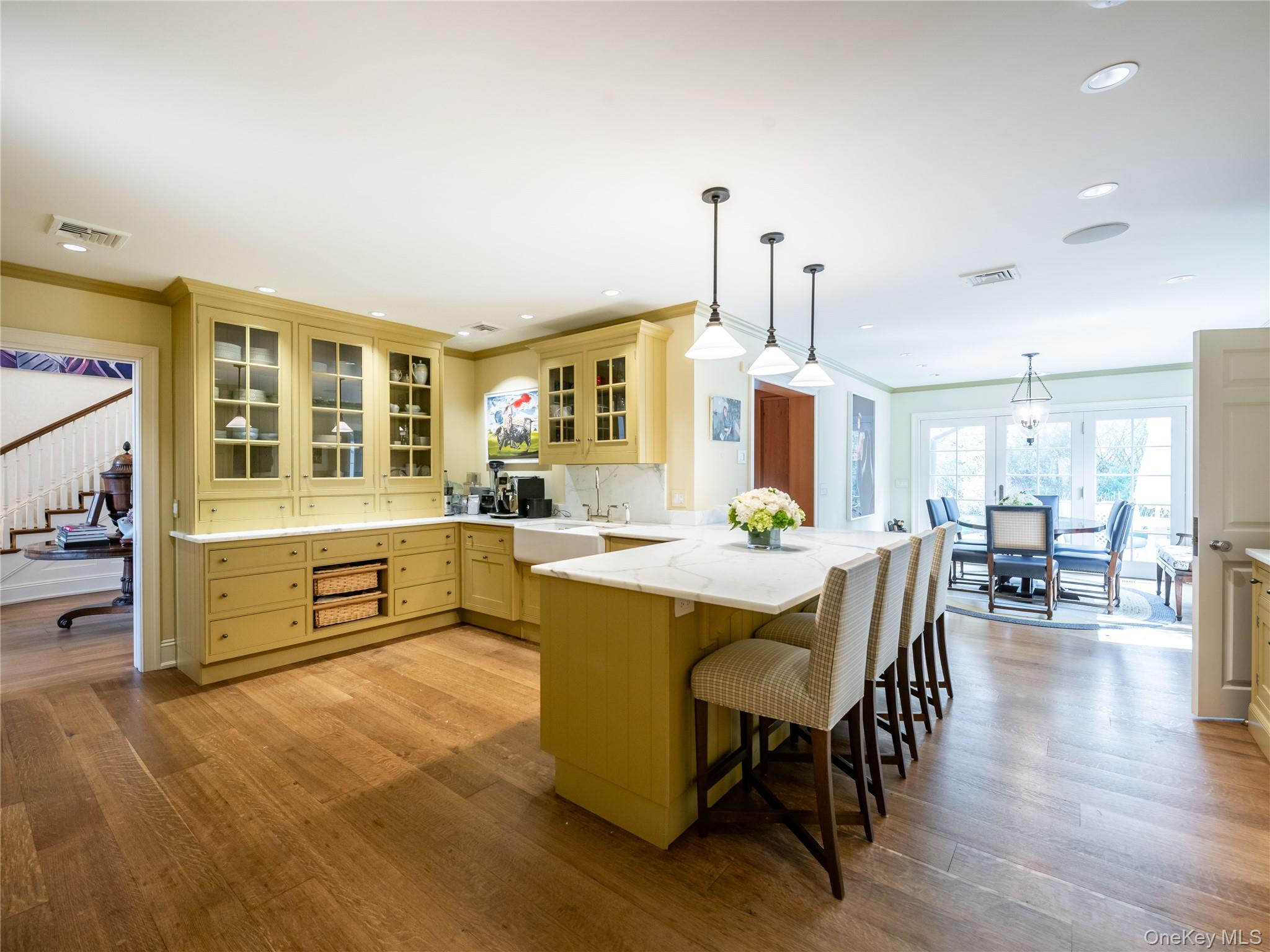 90 Elderfields Road Manhasset, NY 11030 - Photo 14 of 35 a dining hall with stainless steel appliances kitchen island granite countertop a stove a sink a dining table and chairs with wooden floor
