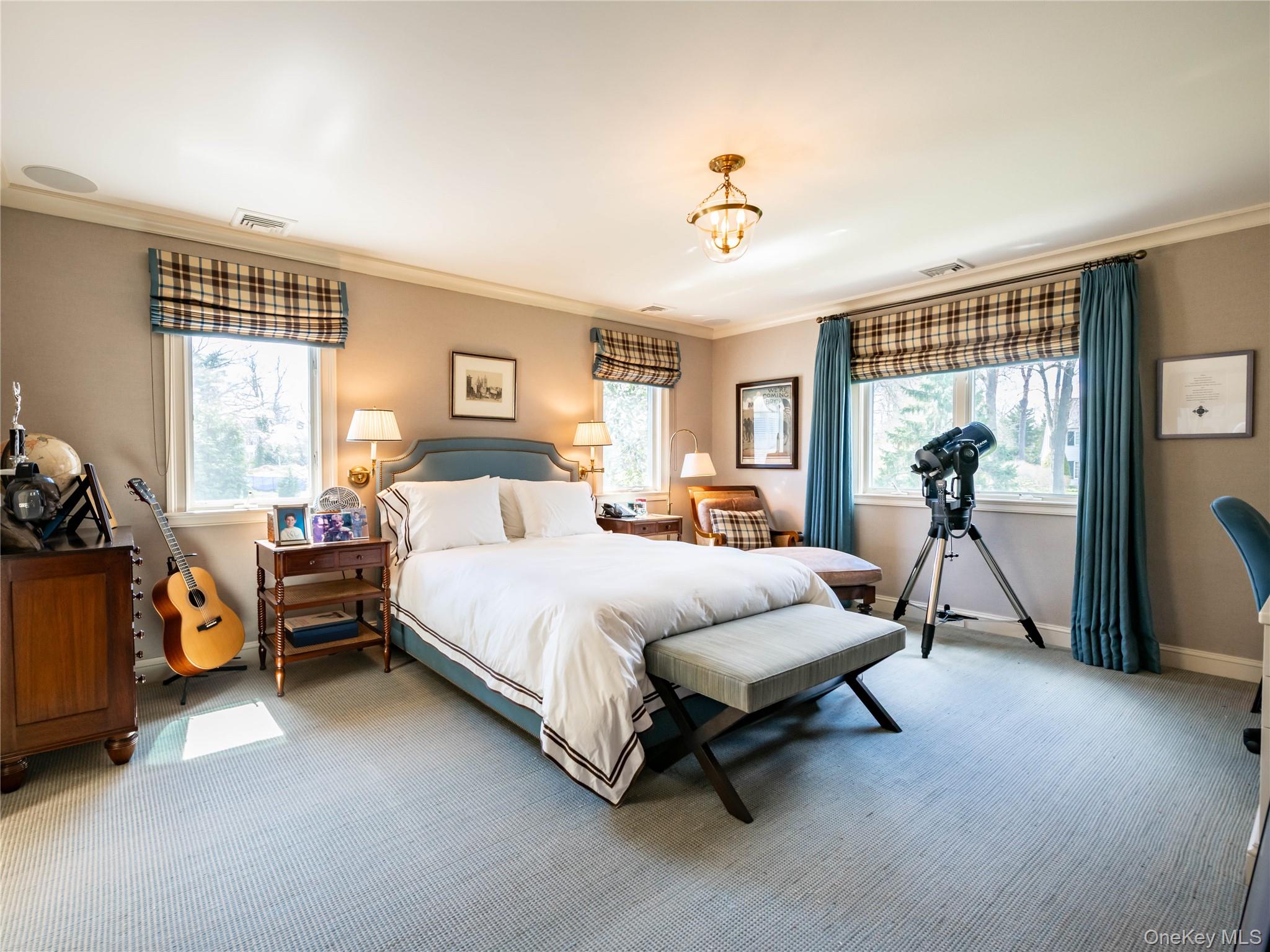 90 Elderfields Road Manhasset, NY 11030 - Photo 28 of 35 a spacious bedroom with a bed and a chandelier