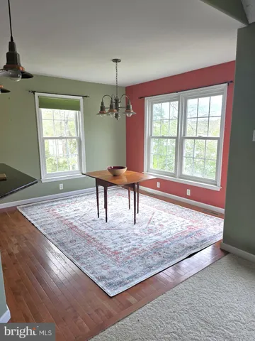 a view of a livingroom with wooden floor and a rug