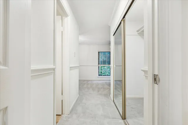 a hallway with painting on the wall and a potted plant