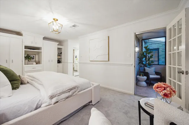 a spacious bedroom with a large bed and a chandelier