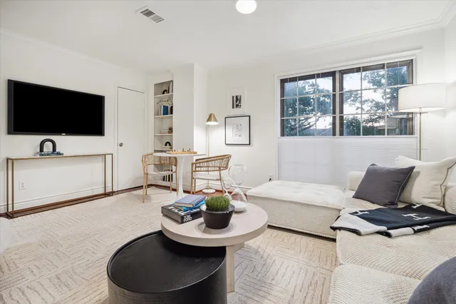 a living room with furniture a flat screen tv and a large window