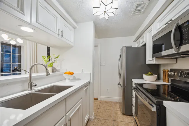 a kitchen with stainless steel appliances a sink a stove and microwave