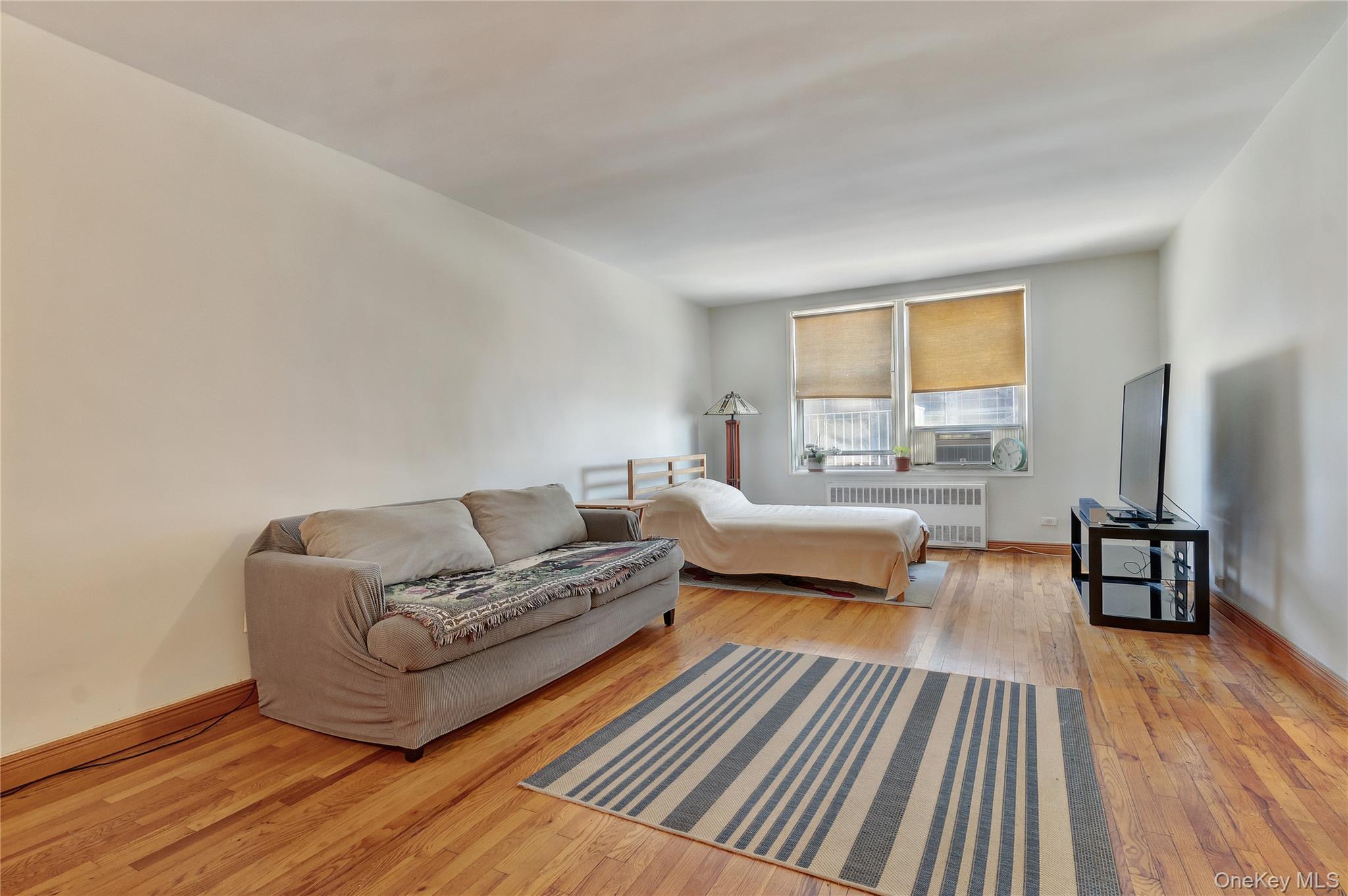 133 Beach 120th Street, Unit 2C Queens, NY 11694 - Photo 7 of 13 a living room with furniture and a wooden floor