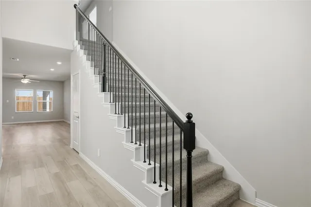 a view of staircase with wooden floor and white walls