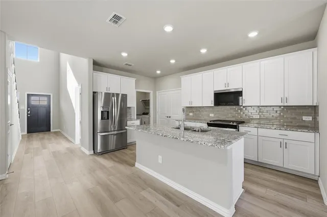 a kitchen with stainless steel appliances a refrigerator sink and microwave